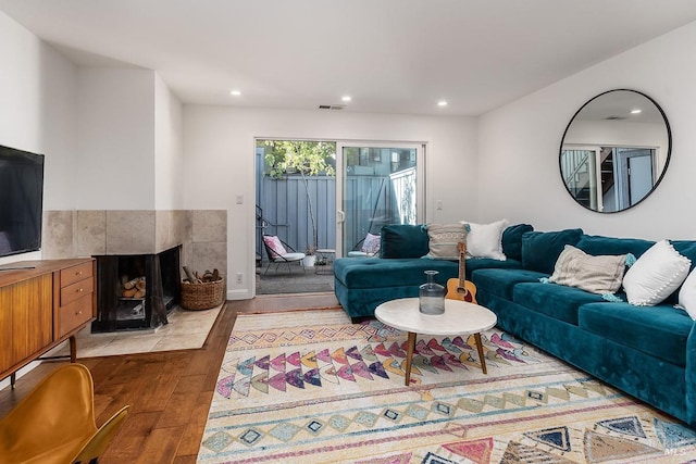 living room featuring light hardwood / wood-style floors and a tile fireplace