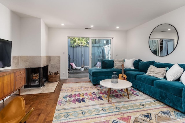 living room with a fireplace, recessed lighting, light wood finished floors, and visible vents
