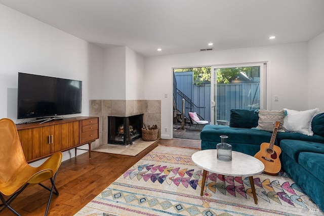 living room with light hardwood / wood-style flooring and a tile fireplace