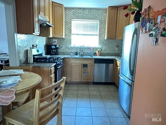 kitchen featuring appliances with stainless steel finishes, sink, backsplash, and light tile patterned floors