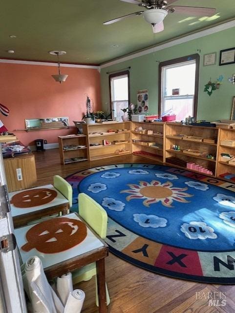 interior space with ornamental molding, hardwood / wood-style flooring, and ceiling fan