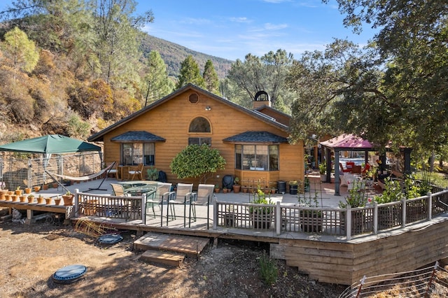 back of house with a gazebo and a deck with mountain view