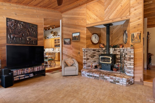 living room with wood walls, a wood stove, vaulted ceiling, and wooden ceiling