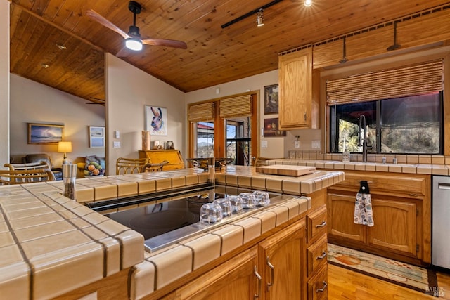 kitchen featuring light wood-type flooring, tile countertops, ceiling fan, wooden ceiling, and vaulted ceiling