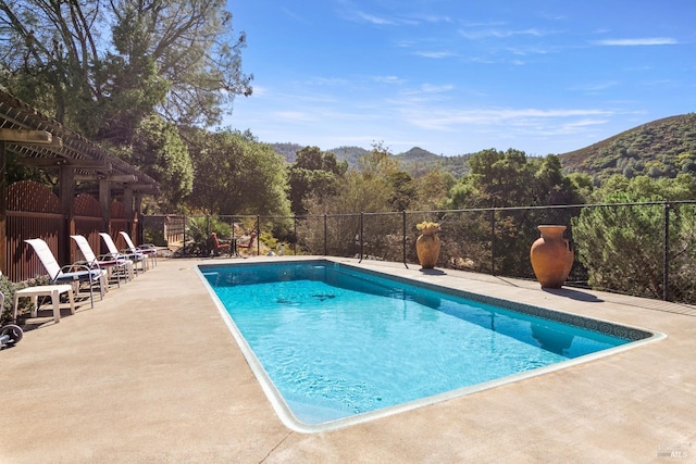 view of swimming pool with a mountain view, a patio, and a pergola