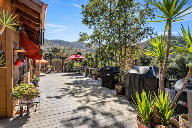 wooden deck with a mountain view and grilling area