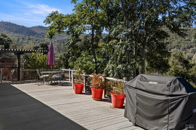 wooden deck with a mountain view and area for grilling