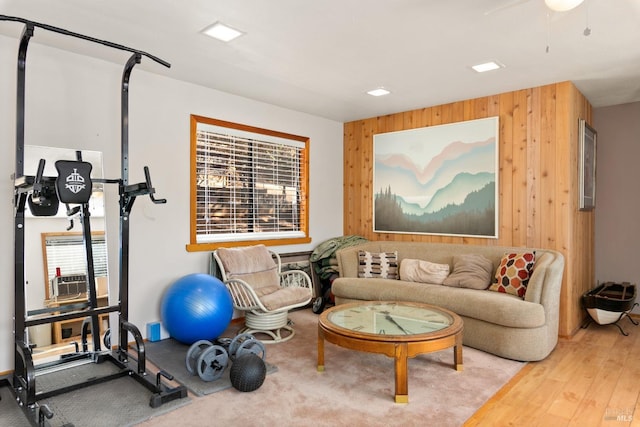 exercise room with wood walls, wood-type flooring, and a wealth of natural light