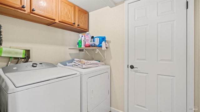 laundry area with washer and dryer and cabinets