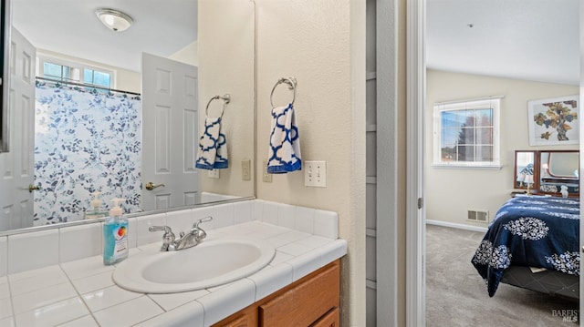 bathroom with a shower with shower curtain, vanity, and vaulted ceiling