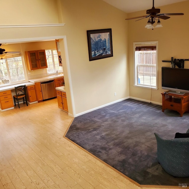 living room featuring ceiling fan, sink, and vaulted ceiling