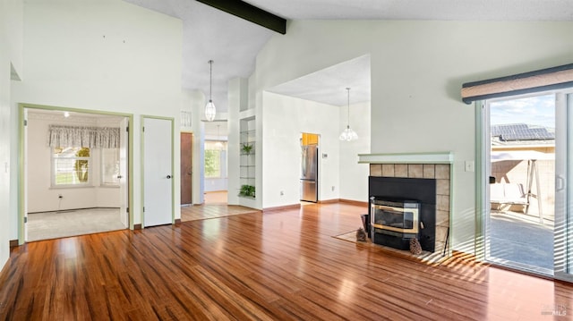 unfurnished living room featuring beamed ceiling, hardwood / wood-style floors, and high vaulted ceiling