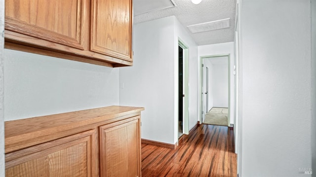 hall featuring light hardwood / wood-style flooring and a textured ceiling