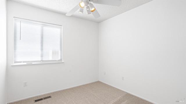 empty room with a textured ceiling, visible vents, and carpet flooring