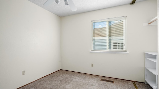 spare room with light colored carpet, a textured ceiling, and ceiling fan