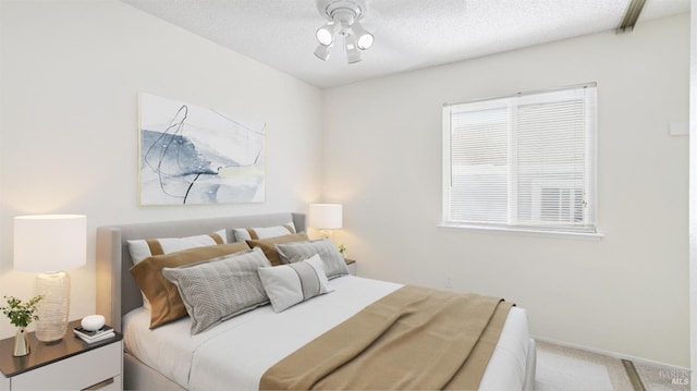 bedroom featuring a textured ceiling, carpet, and baseboards