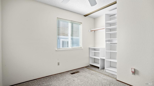 spacious closet featuring light carpet and ceiling fan