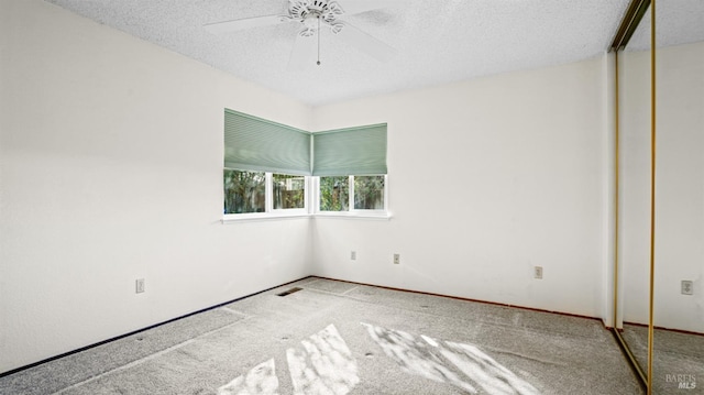 spare room with ceiling fan, carpet floors, and a textured ceiling