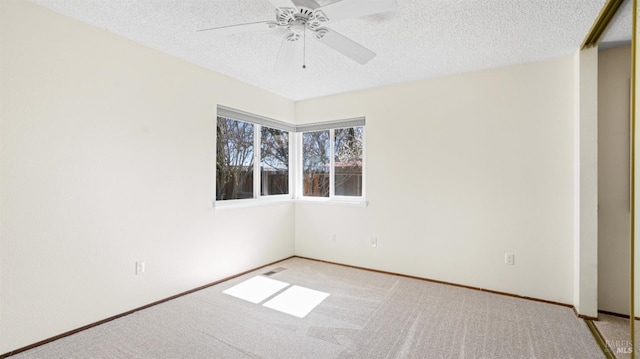 unfurnished room with a ceiling fan, visible vents, light carpet, and a textured ceiling