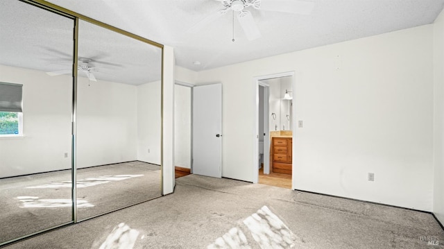 unfurnished bedroom featuring light carpet, a closet, and ceiling fan