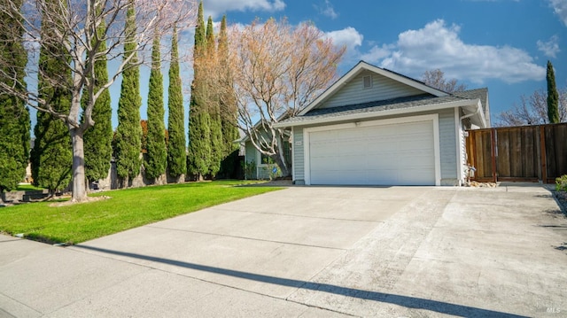 view of front of house with a garage, fence, and a front lawn