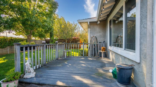 wooden terrace featuring a lawn