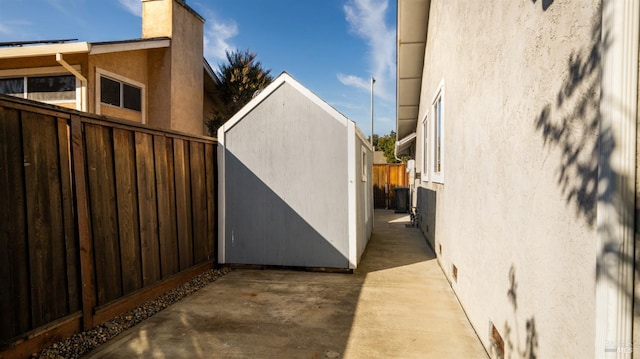 view of side of home featuring a storage shed