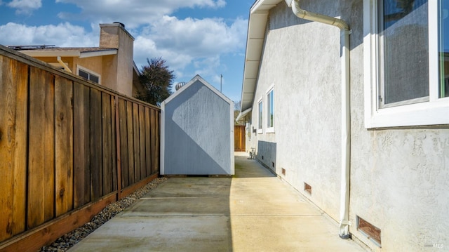 view of side of home with crawl space, fence, a patio, and stucco siding