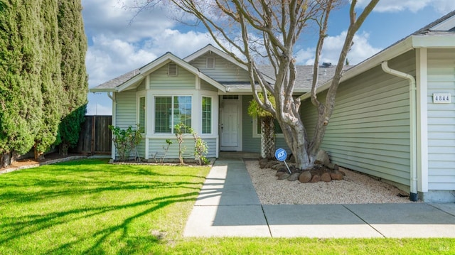 view of front of property featuring fence and a front lawn