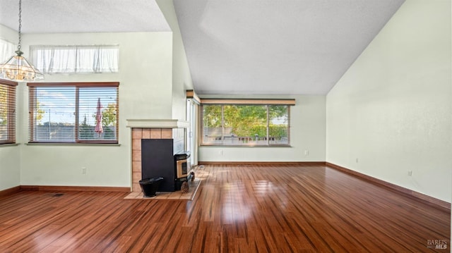 unfurnished living room with hardwood / wood-style flooring, a healthy amount of sunlight, and a chandelier