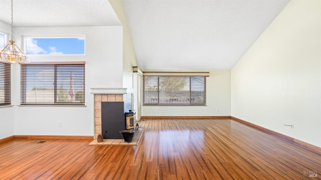 unfurnished living room featuring a wealth of natural light, baseboards, and wood finished floors