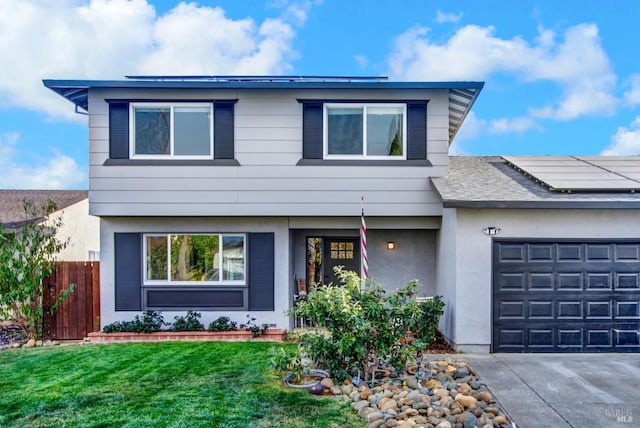 view of front of house featuring a garage, a front lawn, and solar panels