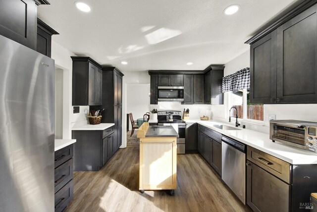 kitchen with dark hardwood / wood-style flooring, sink, dark brown cabinetry, and appliances with stainless steel finishes