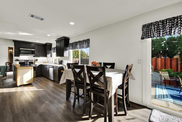 kitchen featuring dark brown cabinetry, stainless steel appliances, dark hardwood / wood-style flooring, and sink