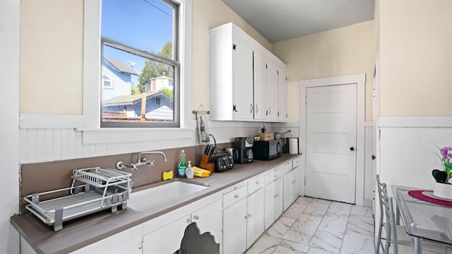 14090 Winnie St, Walnut Grove, CA 95690 - kitchen with light marble finish floors, wainscoting, white cabinetry, and black microwave
