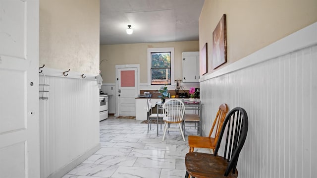14090 Winnie St, Walnut Grove, CA 95690 - kitchen with a wainscoted wall, light marble finish flooring, electric range, and white cabinetry