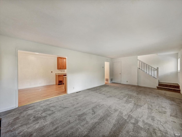 unfurnished living room featuring light colored carpet