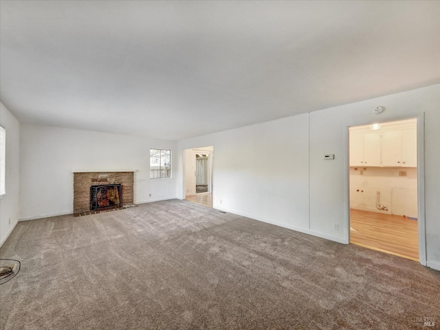 unfurnished living room featuring carpet flooring and a fireplace