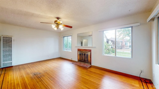 unfurnished living room with a textured ceiling, wood-type flooring, and ceiling fan