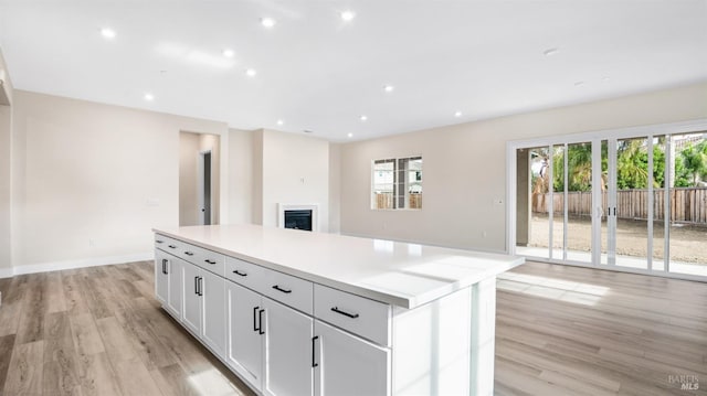 kitchen with a center island, light hardwood / wood-style flooring, and white cabinets