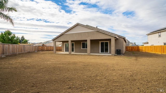 rear view of property with central AC