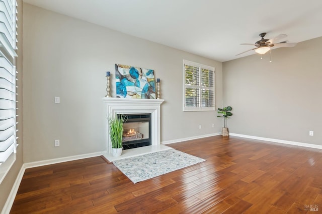 unfurnished living room with wood-type flooring and ceiling fan