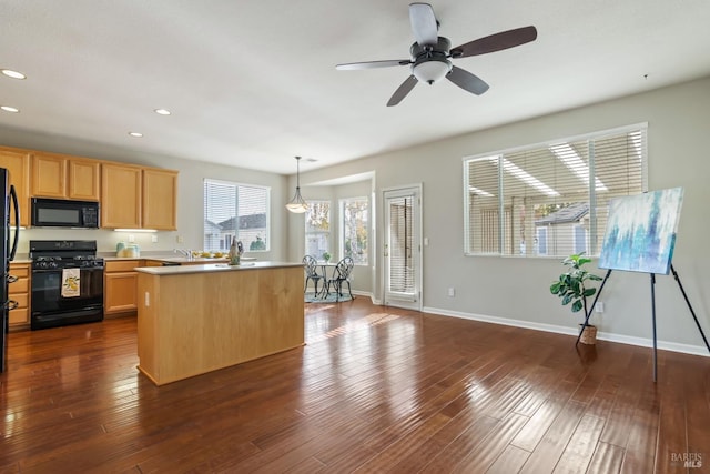 kitchen featuring light brown cabinets, dark wood-type flooring, hanging light fixtures, black appliances, and a center island