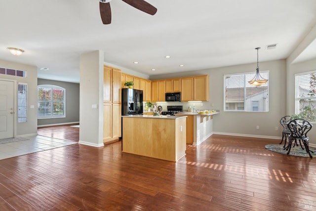 kitchen featuring ceiling fan, light brown cabinetry, black appliances, dark wood-type flooring, and pendant lighting