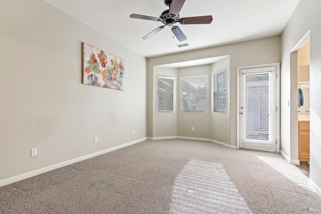 carpeted spare room featuring ceiling fan