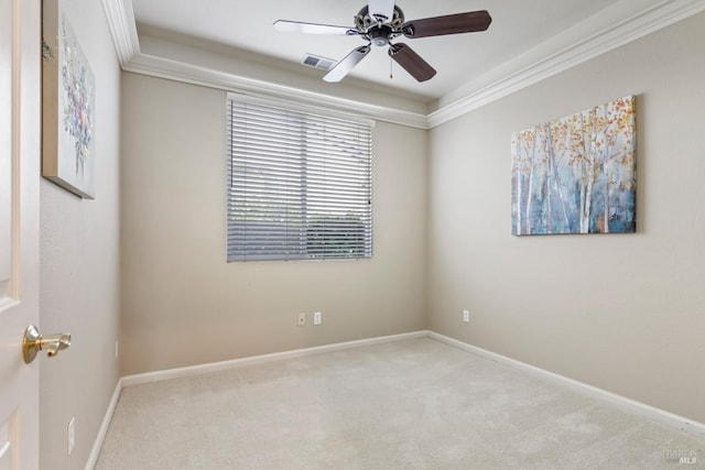 carpeted spare room featuring crown molding, a tray ceiling, and ceiling fan