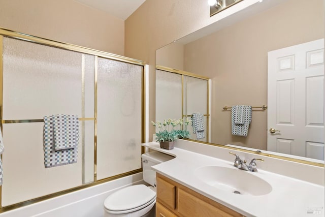 full bathroom featuring vanity, bath / shower combo with glass door, and toilet