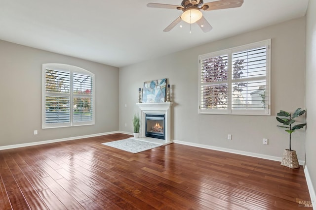 unfurnished living room with dark hardwood / wood-style floors and ceiling fan