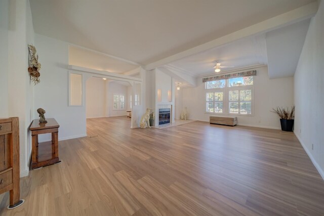 living room featuring a tile fireplace, ceiling fan, and light wood-type flooring