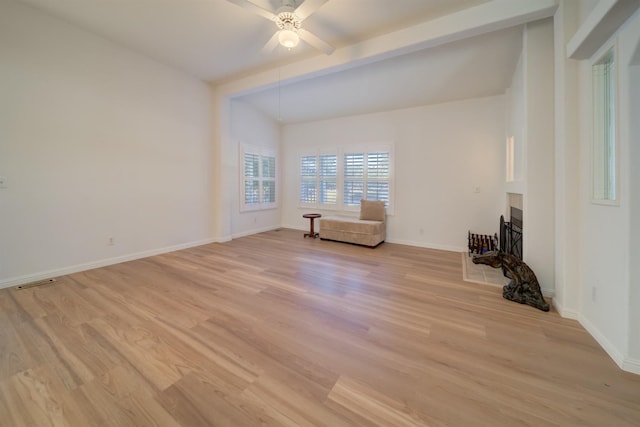 unfurnished room featuring ceiling fan, light hardwood / wood-style floors, and beamed ceiling